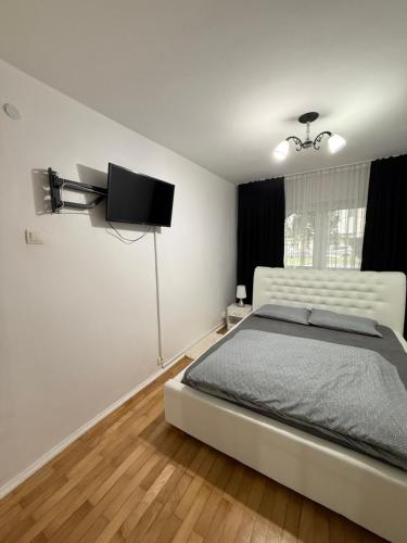 a bedroom with a bed and a flat screen tv at Apartament cozy corner in Caransebeş