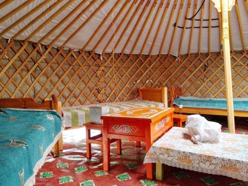 a room with two beds and a table in a yurt at Mongolian traditional Ger accomodation in Narst