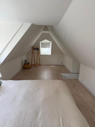 an attic room with a bed and a window at LITTLENEIGHBOUR in Pingjum