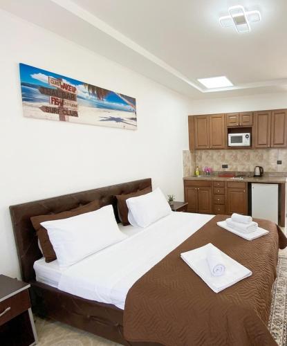 ein Schlafzimmer mit einem großen Bett, auf dem zwei Handtücher liegen in der Unterkunft Button Aparthotel in Dobra Voda