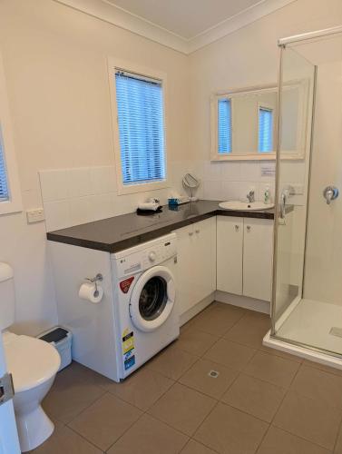 a bathroom with a washing machine and a sink at Clever Kid Wines Vineyard Cottages in Ballandean
