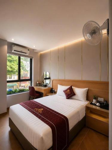 a bedroom with a bed and a desk and a window at Rosy Hotel 8 in Yên Lô
