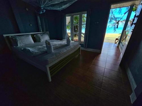a bed in a room with a large window at Longbeach Kohphayam in Ko Phayam