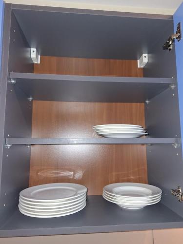 a kitchen with two plates in a cabinet at Cottage Mansart piscine tout équipé in Chaveignes