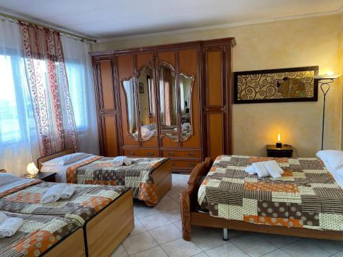 a hotel room with two beds and a mirror at Affittacamere Ramina in San Giuseppe