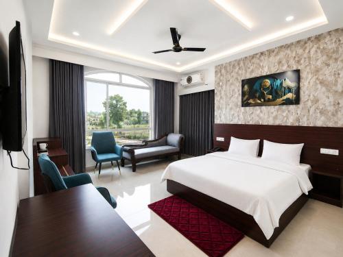 a bedroom with a bed and a desk and a chair at Kamaksha Palace in Sundarnagar