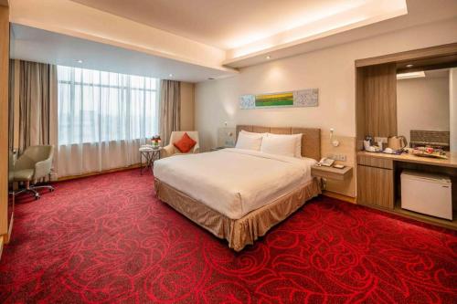 a hotel room with a bed and a red carpet at Dhaka Regency Hotel & Resort in Joār Sāhāra