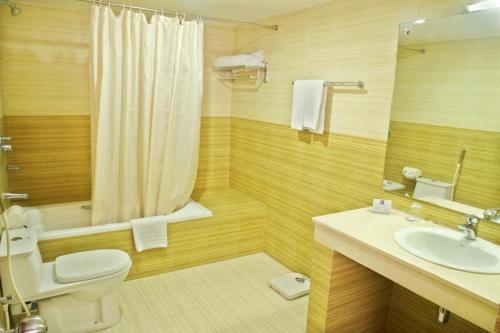 a bathroom with a toilet and a sink and a shower at Dhaka Regency Hotel & Resort in Joār Sāhāra