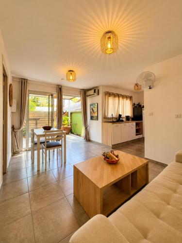 a living room with a couch and a table at Cocon Romantique in La Saline les Bains