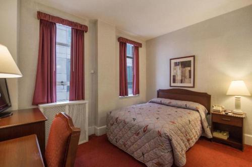 una camera da letto con un letto, una scrivania e finestre di Hotel Harrington a Washington
