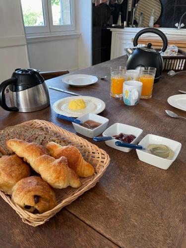 a table with a basket of bread and other breakfast foods at Chateau de Bouquetraud in Franchesse