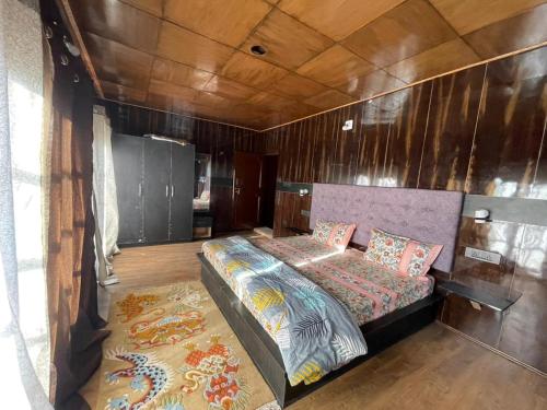 a bedroom with a bed and a wooden wall at Larikha stay chumpa in Leh