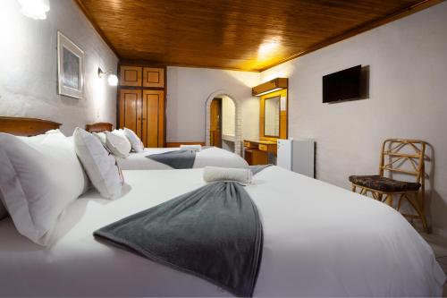 a bedroom with two beds with white sheets at Merino Inn Hotel in Colesberg
