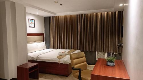 a hotel room with a bed and a table and a chair at Cherry Midtown Hotel in Bahac-bahac