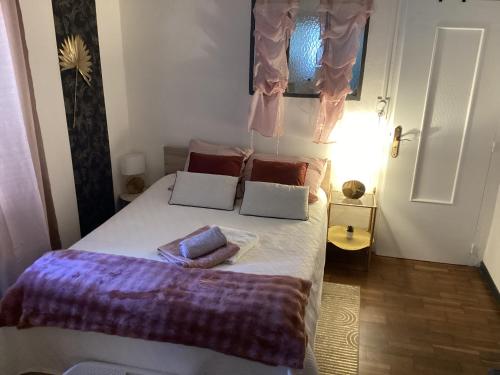 a bedroom with a bed with two pillows on it at Un petit truc en plus in Brienne-le-Château