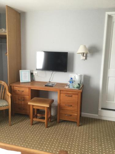 a desk with a television and a chair in a room at The Haymaker Inn in Chard