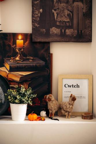 a shelf with a picture of a book and two stuffed dogs at 4 Walkers Cottage - Cosy, dog friendly with private unique BBQ hut! in Pont Sticill