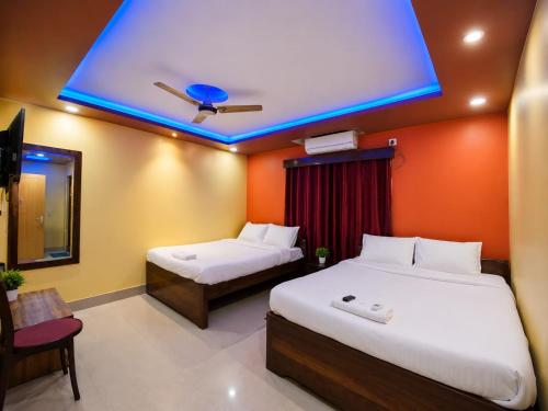 a bedroom with two beds and a blue ceiling at DAS HOTEL in Darjeeling