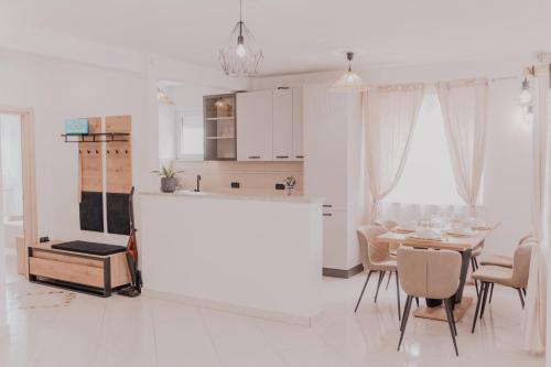 a white kitchen and dining room with a table and chairs at Zen Suite in Umag