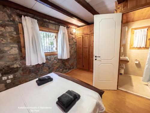 a bedroom with a large bed and a bathroom at Kefalonian Luxury Villas in Kástron