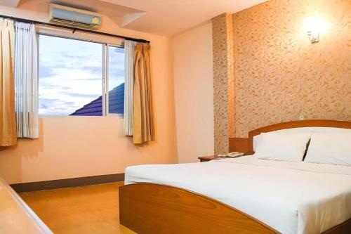 a bedroom with a large bed and a window at Phuthong Place in Phayao