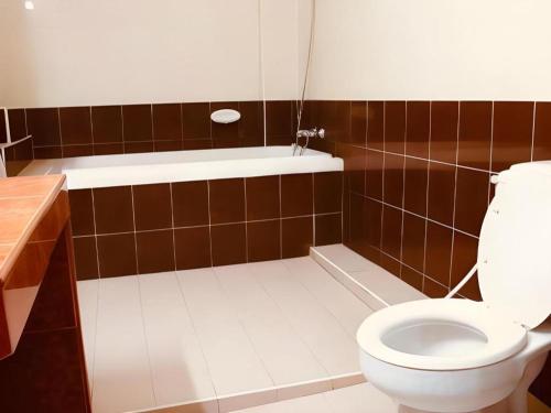 a bathroom with a toilet and a bath tub at Phuthong Place in Phayao