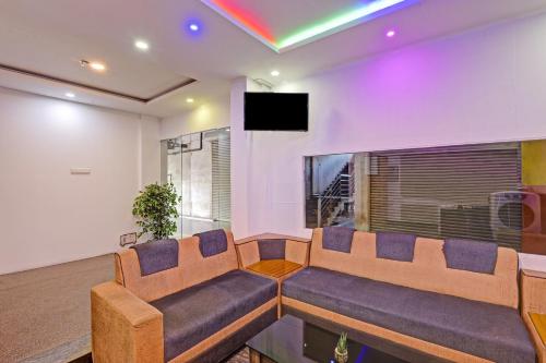 a living room with a couch and a tv at Collection O EXPRESS SUITES in Calicut