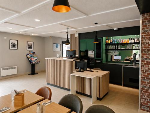 a restaurant with a bar and tables and chairs at Kyriad Direct Le Bourget Gonesse in Gonesse