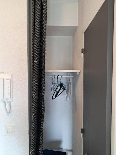a closet with a shelf with a pair of glasses at STUDIO COSY PROCHE PLAGE, tout à pied in Pornichet