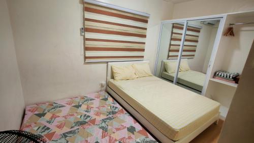 a small bedroom with a bed and a mirror at Janice Place 2 in Marilao