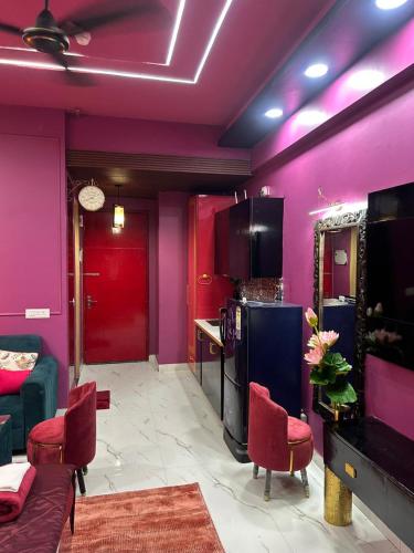 a living room with purple walls and red ceilings at THE MOONLIGHT STUDIo in Ghaziabad