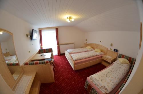 a small room with two beds and a mirror at Garni Ossi in Santa Cristina Gherdëina