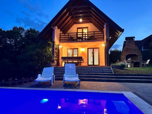 a house with two chairs and a swimming pool at Foresta Home in Gradačac