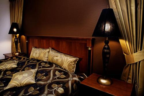 
a bedroom with a bed and a lamp at Hotel Tønderhus in Tønder
