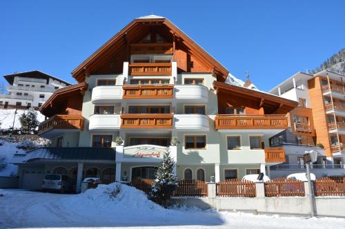 a large white building with a wooden roof at Hotel Garni Alpenhof in Ischgl