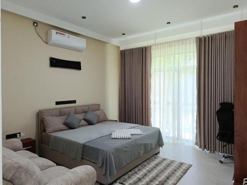 a bedroom with a bed and a large window at Isle Weligama in Weligama