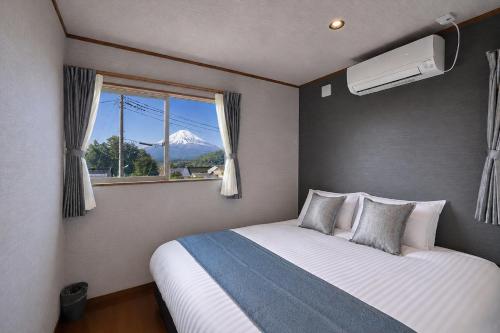 a bedroom with a bed with a view of a mountain at TOCORO Mt Fuji Shizuku in Fujikawaguchiko