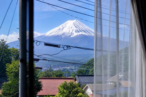 a view of a snow covered mountain from a window at TOCORO Mt Fuji Shizuku in Fujikawaguchiko
