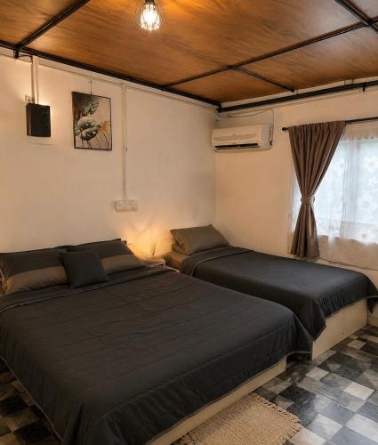 a bedroom with two beds and a window at SABAYA HOMESTAY in Balik Pulau
