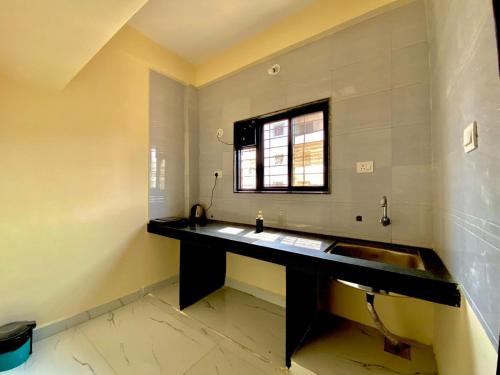 a bathroom with a sink and a window at Joy Suites and Hostel in Pune