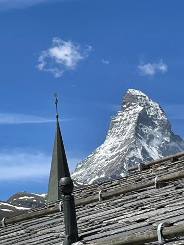 a snow covered mountain sitting on top of a roof at Haus Rosa in Zermatt