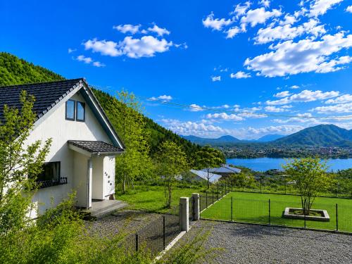 a house with a view of a lake and mountains at tocoro. Mt. Fuji Mutsuki in Fujikawaguchiko