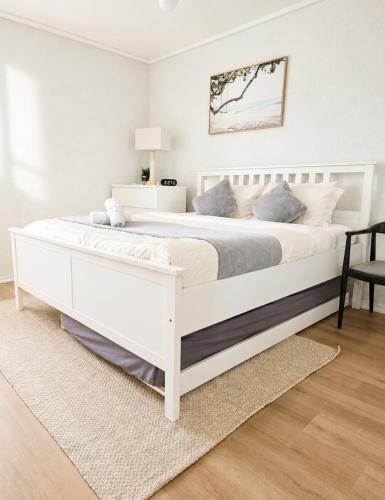 ein weißes Schlafzimmer mit einem großen weißen Bett in der Unterkunft Semaphore beachfront in Semaphore