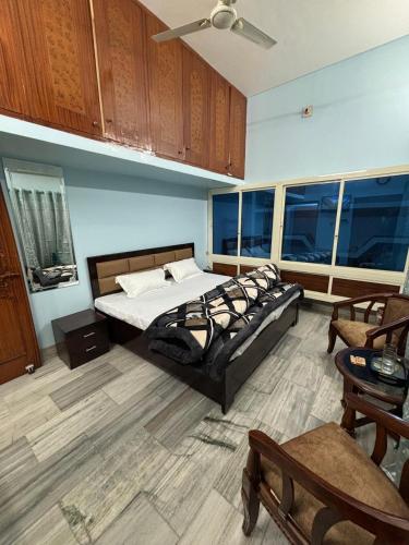 a large room with a bed and chairs and windows at RAMRAJ GUEST House in Ayodhya