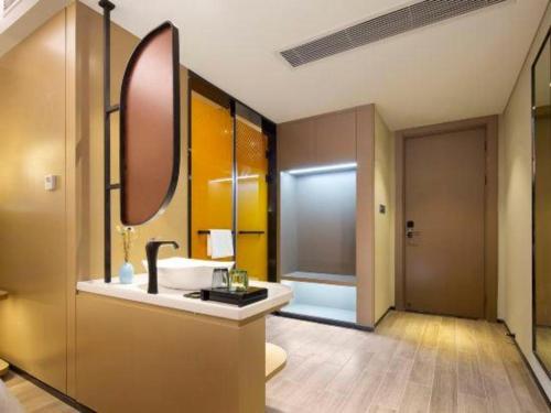 a bathroom with a sink and a mirror at mango crystal hotel in Haikou