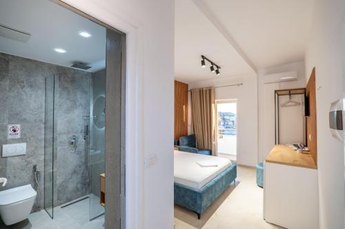 a bathroom with a shower and a bed in a room at Vila Naço Ksamil in Ksamil