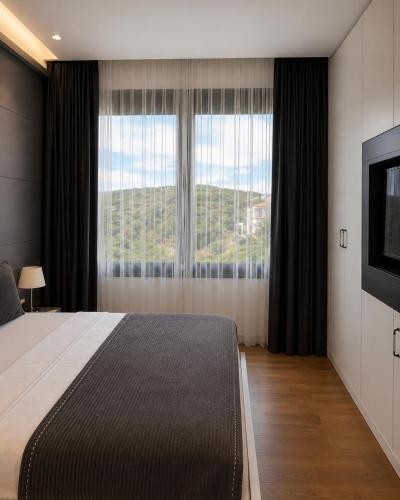 a bedroom with a large bed and a large window at Cunda EYE in Cunda