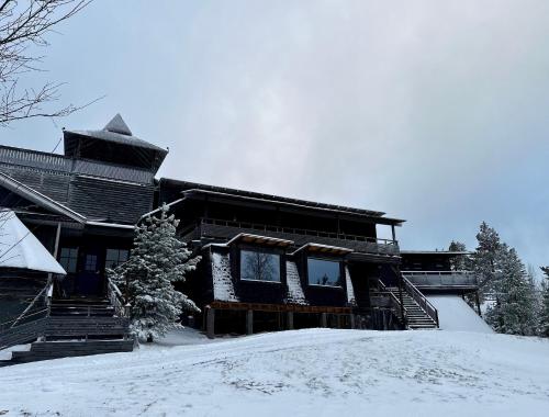 a large wooden house with snow on the ground at Jättiläisenmaa in Paltamo