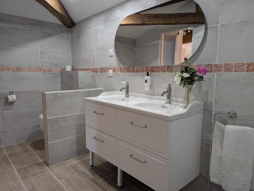 a bathroom with a white sink and a mirror at Maison d'Hôtes Le Clos de Bacchus in Julienne