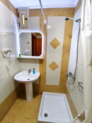 a bathroom with a sink and a shower at Kiparissis Apartments in Kriopigi